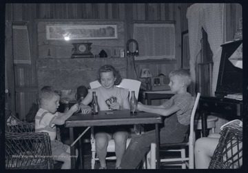 Miller Murrell, at right, and family play cards at a folding card table.
