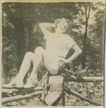 Davis is pictured sitting on top of a wooden fence. 