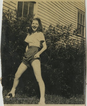 An unidentified female student poses on a lawn. 