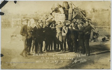 Photo reads, "Behold thy worthy prodigy, Sol? thine own 'Scrubby'."  Fans of the West Virginia University football team pose together with a sign that says, "W. & J. had good form but that was all."  West Virginia University won the game 7-0.