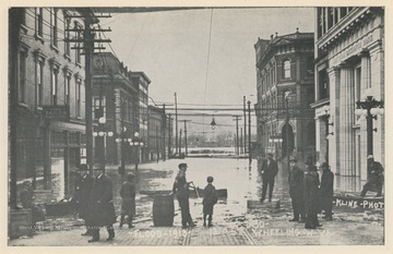 Photo postcard showing 18th Street during the 1913 flood in Wheeling, W. Va. Postcard is part of a souvenir book of 1913 flood images.