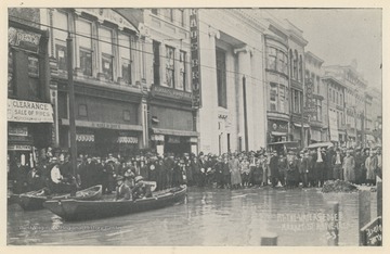 Photo postcard of Market Street above 14th Street during a 1913 flood in Wheeling, W. Va. Several business signs are visible including Bolton's, Kraus Brothers, and C.A. House Pianos. Postcard is part of a souvenir book of 1913 flood images.