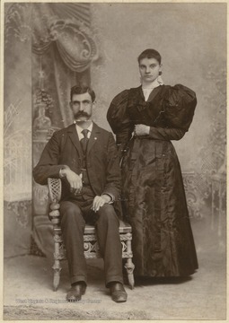 A man and a woman identified as Jollife family members are pictured in the Stewart and Wise photo studio. 