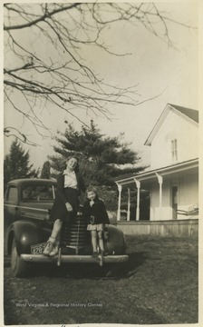 Knott, left, and Morlan, right, sit on the hood of a car outside of a home in Newburg. 
