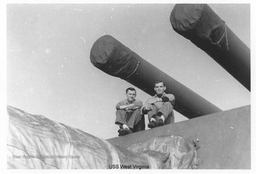 The two men in the photo are sitting on top of or near one of the gun turrets on the ship.  Photos are from an album belonging to a crew member of the U.S.S. West Virginia.  William Wright, Radio Technician 2C, was on the ship from 1944-45 and saw action at Leyte Gulf, Iwo Jima, and Okinawa. 