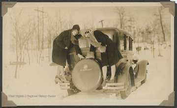 "From Morgantown to Hopemont."  Two women, identified as Sara and Pansy, stand on the rear bumper of a Studebaker President belonging to Arthur Beaumont.