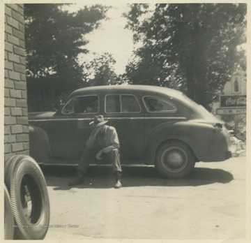 Butcher leans against an automobile outside the store in Lewis County, W. Va.