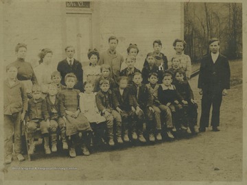 A group of school children and teachers are pictured outside of the school building. Subjects unidentified. The photograph comes from a photo album belonging to Mrs. Earl R. Zinn.