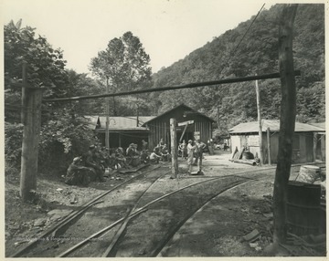 A group of coal miners are gathered outside of the mining facilities likely somewhere in West Virginia or Pennsylvania. Subjects unidentified. 