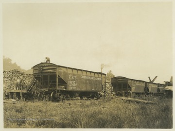Miners stand beside the Chesapeake and Ohio Railway cars. Subjects unidentified. 