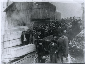 A group of men inspect the damage caused by an explosion at the mine. Subjects unidentified. 