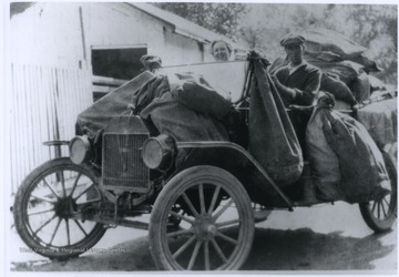 The older horse delivery method was replaced by this Ford automobile, driven by Mr. Thompson.