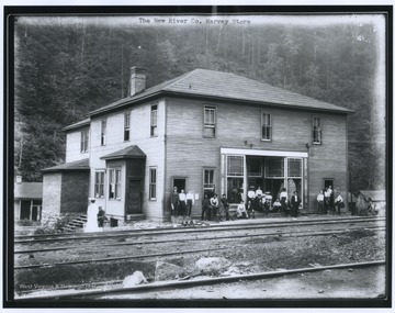 A group of men, women, and children are pictured loitering in front of the store entrance. 