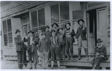 A group of men with bottles are pictured in front of the saloon entrance. 