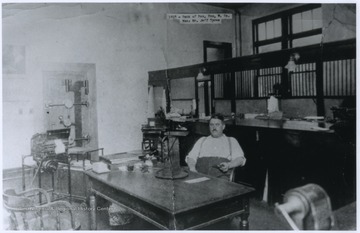 Bank manager Mr. Jeff Tyree is pictured sitting behind a desk inside the bank building.