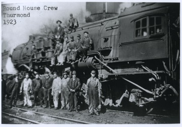 A group of men are pictured on and beside a locomotive. Subjects unidentified. 