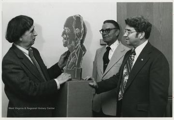 Kramer, left, inspects mock sculpture of dentistry faculty member J. B. Rolunseir. 