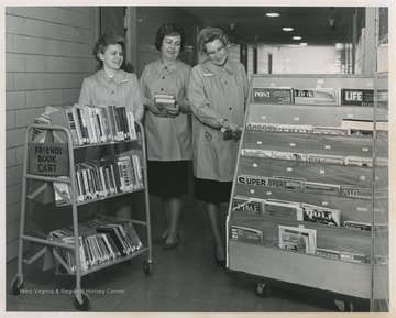 Three women collect books and magazines for patients at University Hospital. 