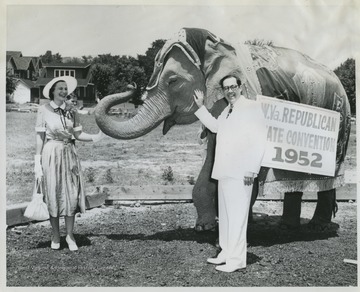 Rush Holt and his wife, Helen Holt, smile as they pet an elephant. 