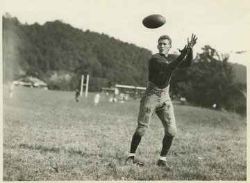 Glenn prepares to catch a football during football practice. 