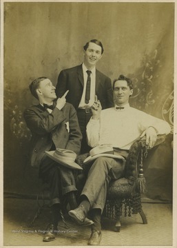 Three unidentified men are pictured together in a photo studio.