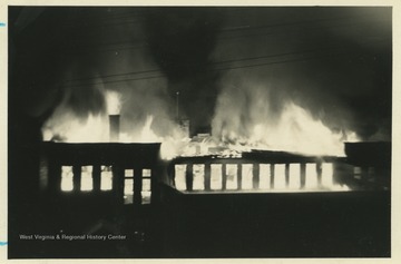 Photograph shows the third floor fully engulfed in flames while the auditorium below has yet to catch fire. 