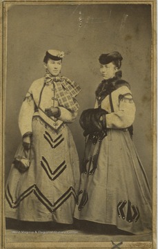 The two women, likely sisters, are dressed in warm clothes.