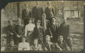 "This was taken at "Holly Hall" as the house is called. Mrs. Schiltz is standing and Mrs. Lane and Clarice Schiltz are sitting on the ground. The two boys standing on top of the wall are the Schiltz boys."Pictured in the middle row, second from left, is E. B. Schiltz.This photograph is found in a scrapbook documenting the survey for the Baltimore and Ohio Railroad in West Virginia and surrounding states. 