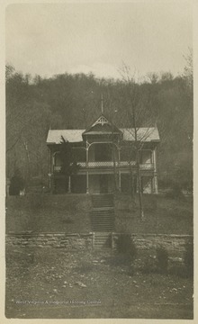 ""Holly Hall" from the front. The stake shown in the foreground, at the bottom of the picture is Sta. 161 of our Location."This photograph is found in a scrapbook documenting the survey for the Baltimore and Ohio Railroad in West Virginia and surrounding states. 
