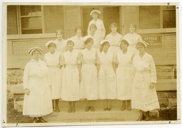 A group of nurses standing outside of Monongalia County Hospital, which was located on the corner of Willey and Prospect Streets in Morgantown.