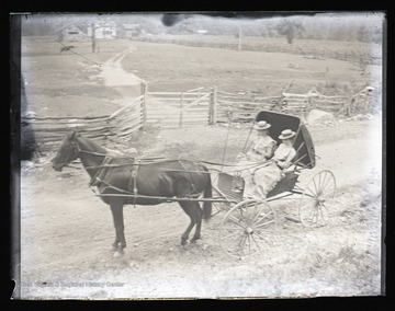 Two women in a horse drawn wagon, likely near Franklin, W. Va.