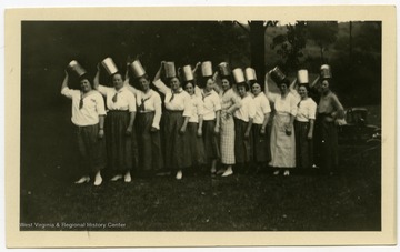 Group photo of the Stonewall Club.  Members pose in a stunt pose with pots or tins on their heads.