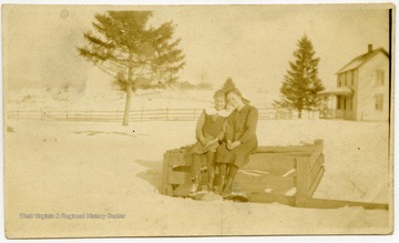 Carrie Harper Harman (on right) and unidentified woman sitting on a bench.