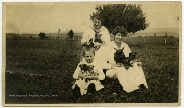 Unidentified members of the Harper family with puppies.