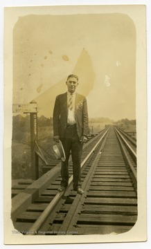 Bid Harper standing on railroad tracks.