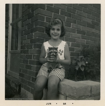 Girl with pet raccoon.