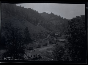 A row of houses sits next to railroad in a valley