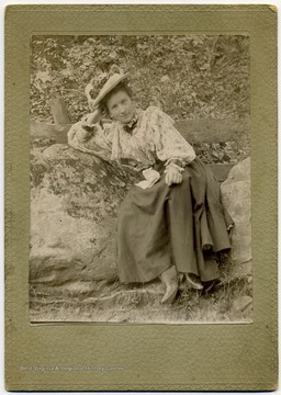 Linnie Jernewine poses for a photograph in front of wooden fence.