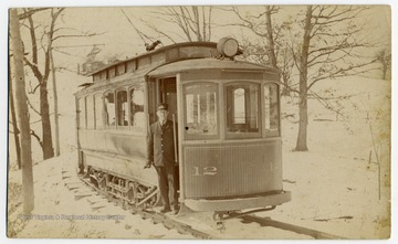 The conductor stands in the door of streetcar 12. Text on the back reads, "This is the streetcar that ran from Morgantown down to Osage."