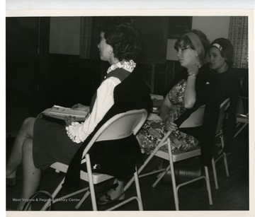 Three women sitting in a meeting.