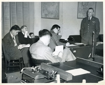 C. B. Allen is seated on the far left. He reported military and Veterans Administration news as a member of the Washington bureau of the New York Herald Tribune from 1946 until 1953. Major General William H. Tunner is conducting the briefing.