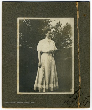The young woman pictured is likely Ruth Frances Maxwell, Louis Johnson's wife. The text on the corner reads, "Mostly yours."
