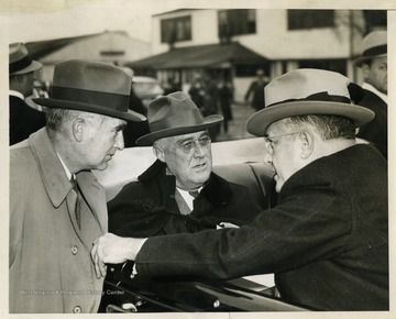 Text on the back reads: "Charles Edison, Assistant Secretary of the Navy; President Roosevelt; and Louis Johnson, Assistant Secretary of War, as the President made an inspection of various types of aircraft at Army's Bolling Field and Naval Air Station." 