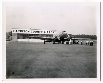 People gather for an opening ceremony of an airline at Harrison County Airport, now called Benedum Airport.