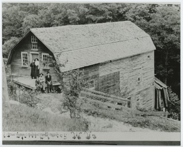 Five people pose in front of a large barn-like structure in rural Preston County, W. Va.