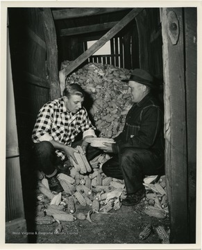 William D Wilhem, left, 1953 corn growing champion, and father, J.W. Wilhelm, right.