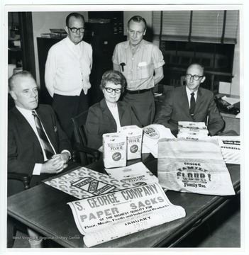 The S. George Company produced flour sacks and printed flour barrel labels. The woman seated in the middle of the picture is (Katherine) Jane Watson, the company's bookkeeper.