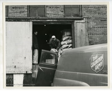 "Cartons of butter being loaded onto supply truck as part of revamped food distribution program emphasized by President Kennedy under Executive Order Number 1. Butter will be taken to distribution center and given to needy persons."