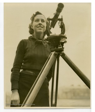 Esther Benford, the only woman student in West Virginia University College of Engineering at the time, with surveying scope. 