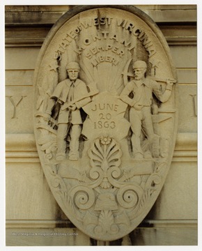 A stylized rendition of the West Virginia state seal, done in stone.